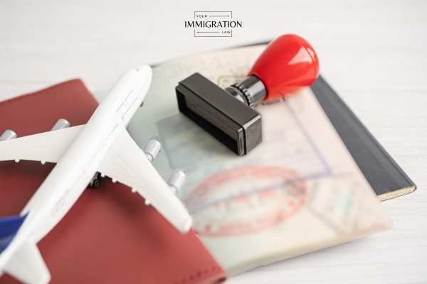 a model plane, passport, and stamp on a white table