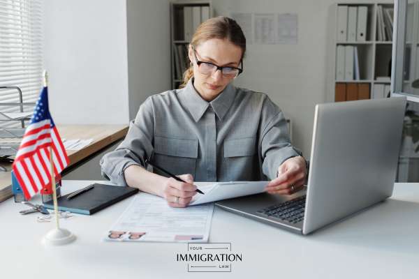 a visa application being reviewed by a USCIS employee