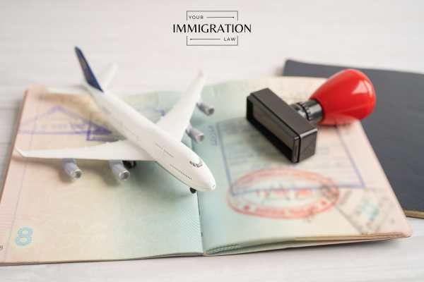 a passport, model plane, and stamp on a table