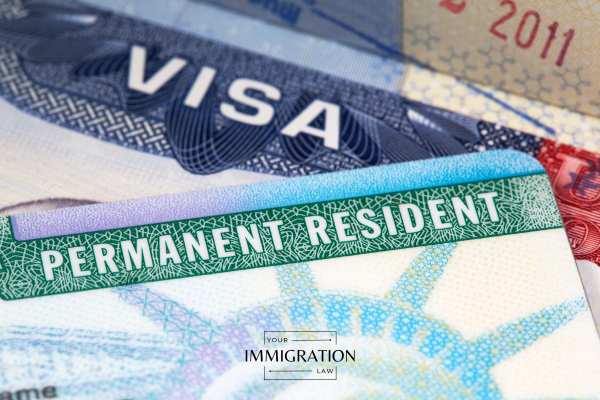 a visa and green card on a desk