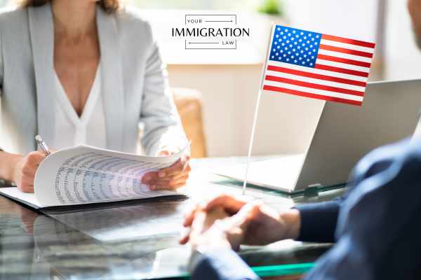 a USCIS employee taking notes during a green card interview