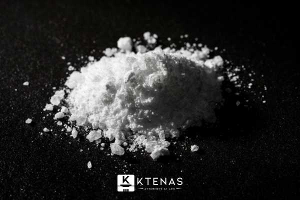 a relatively small amount of powdered drug on a black table