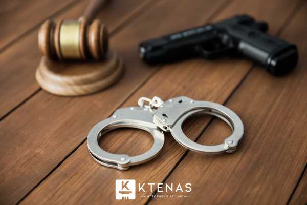 a pistol handcuffs and gavel on a table