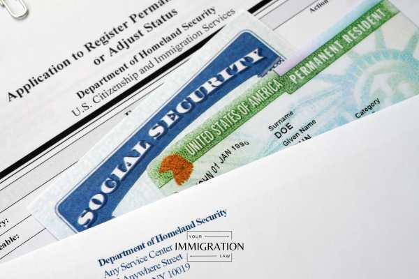 a green card and immigration forms on a clipboard