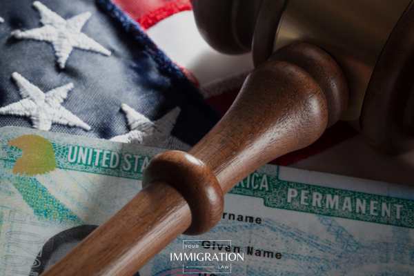 a green card and gavel on an american flag