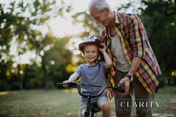 a grandfather teaching his grandson to ride a bike
