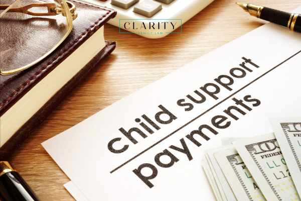 a child support payment form, money, and a calculator on a desk