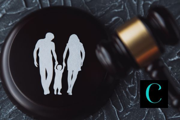 a paper cutout of a family on top of a gavel with the hammer next to it