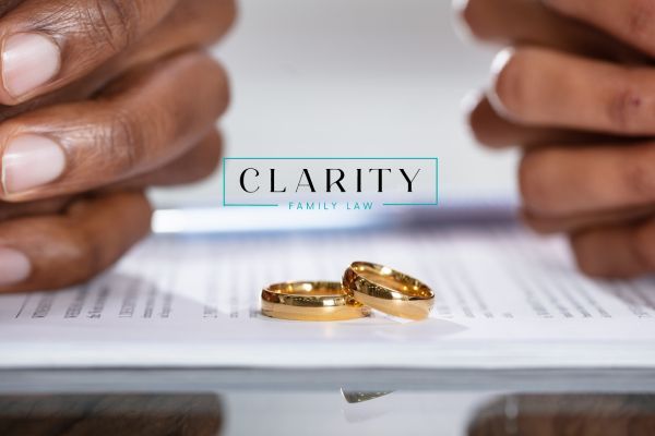 two people sitting across from each other discussing their divorce with their wedding rings in front of them