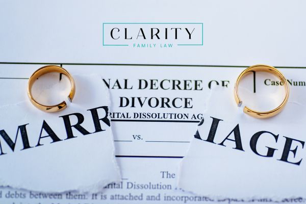 a divorce decree underneath a paper that has the word marriage on it with two wedding rings