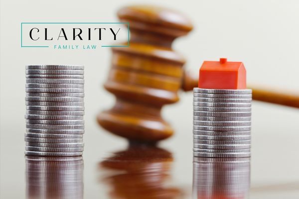 a gavel with stacks of money and a toy house in front of it