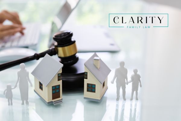 a gavel sitting behind a house that's split in half with a family on both sides
