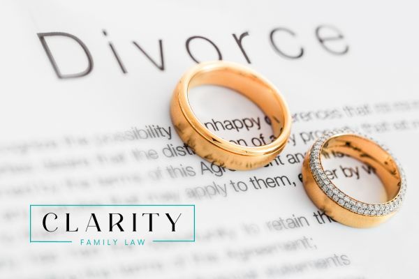 two wedding rings sitting on a divorce document