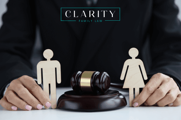 Man and woman figurines being held next to a gavel.