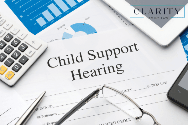 Paper labeled child support hearing with a calculator and reading glasses.