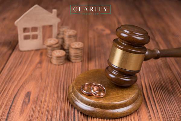 a gavel, 2 wedding rings, and a model home on a desk
