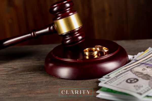 a gavel, wedding rings, and cash on a desk