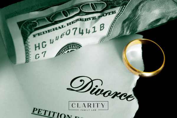 a divorce form, wedding ring, and money on a black background