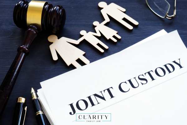 a cutout of a family, custody paperwork, and a gavel on a desk