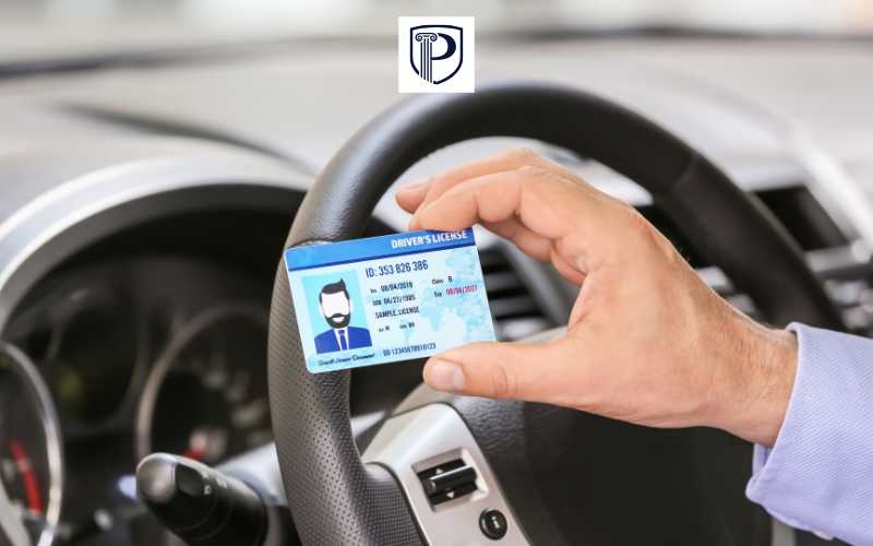a man holding his license in the drivers seat of a car
