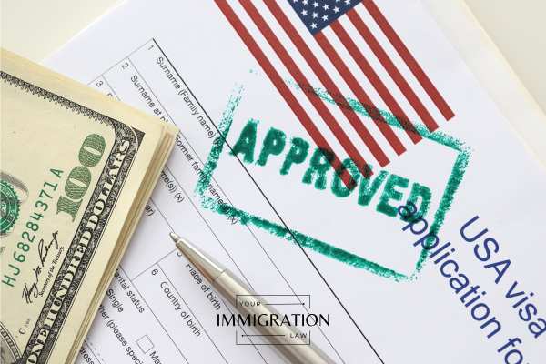 an approved visa application and money on a desk