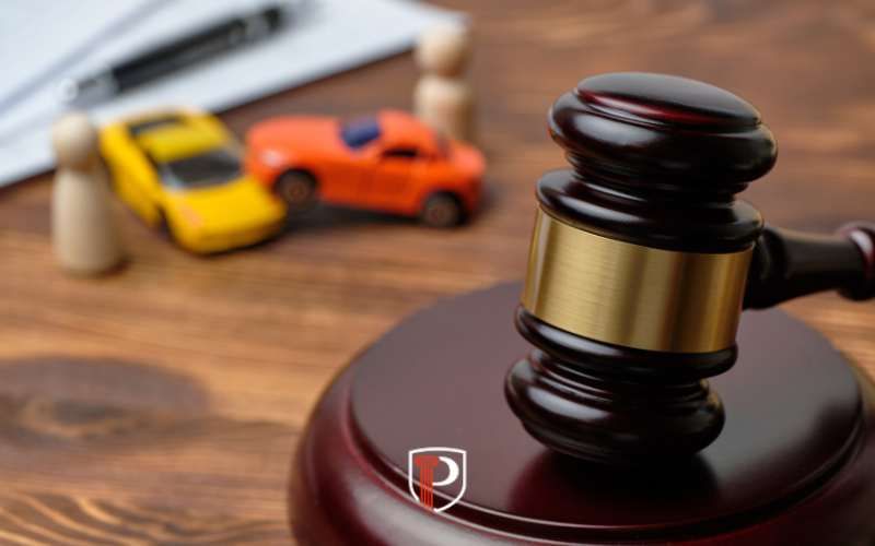 a gavel, legal documents, and model cars on a desk