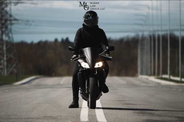 a motorcyclist stopped between two lanes on a road