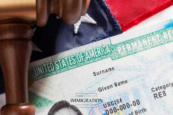 a permanent residency card and gavel on an american flag