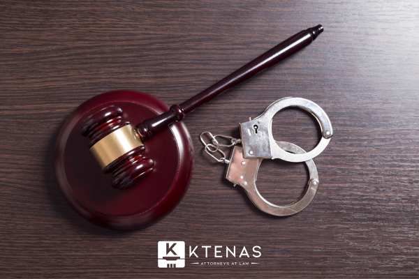 a gavel and handcuffs on a wooden desk