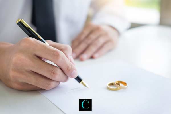 a man at a desk signing divorce papers