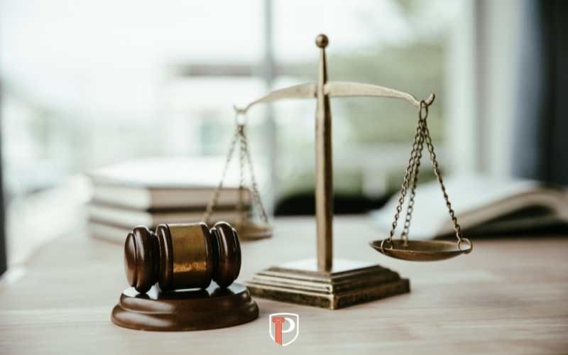 a desk in an office with law books, scales of justice, and a gavel on it