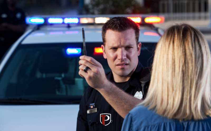 a police officer having a woman perform a field sobriety test