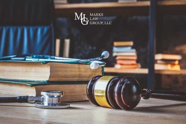 a desk with ilegal books, a gavel, and stethoscope on it