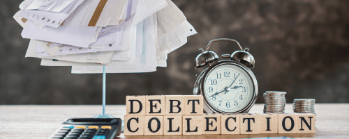 A wind-up alarm clock, a stack of papers, and a selection of wooden alphabet blocks rest on a desktop. The blocks spell the words "Debt Collection." The image conveys the sense of pressure and stress that is triggered by debt collection harassment and the need for the Consumer Justice Law Firm to help.