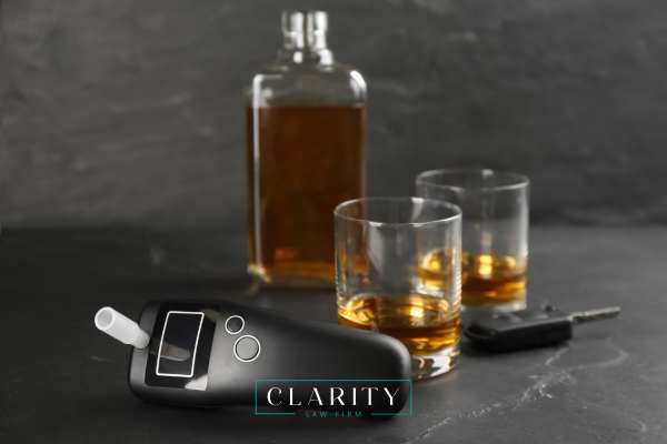 car keys, a breathalyzer, and whiskey on a table
