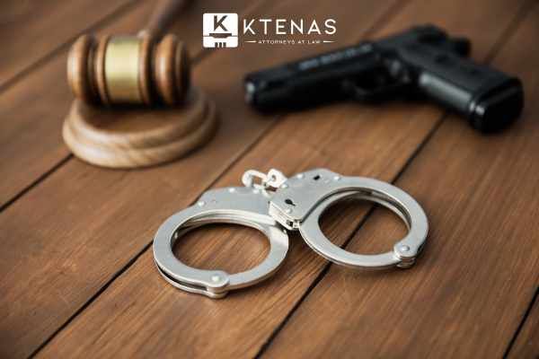 handcuffs, a gavel, and a pistol on a wooden table