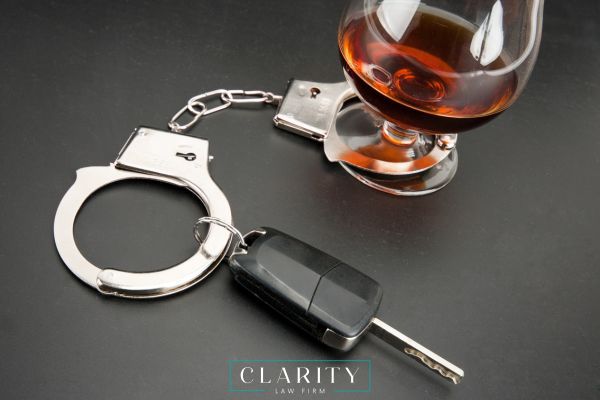 handcuffs, alcohol, and car leys on a black table