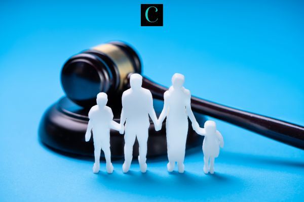 a gavel and model figures of a family in front of a blue background