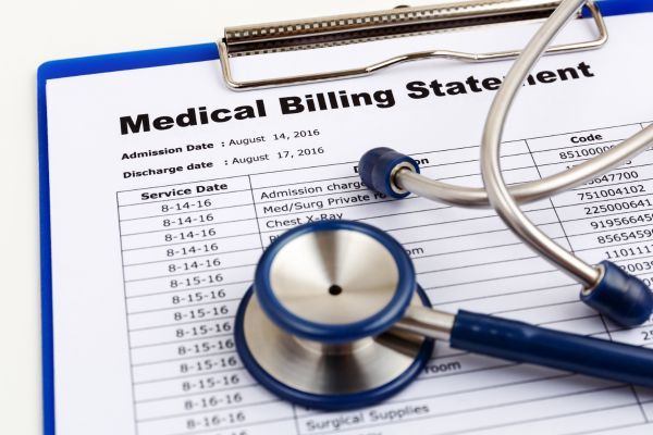 A stethoscope rests on a medical billing statement