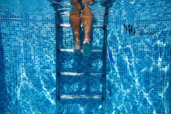 Underwater view of a person climbing a pool ladder.