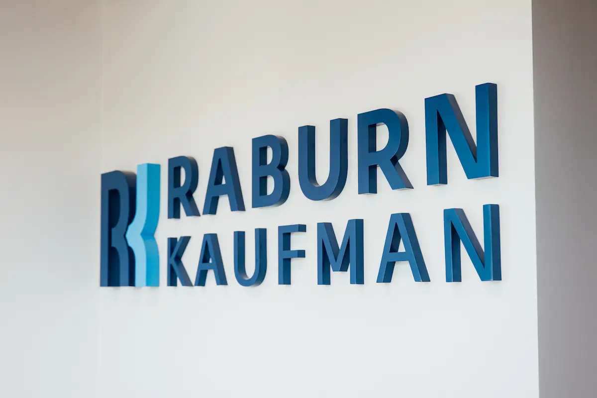 The Raburn Kaufman name in dimensional letters on a white office wall
