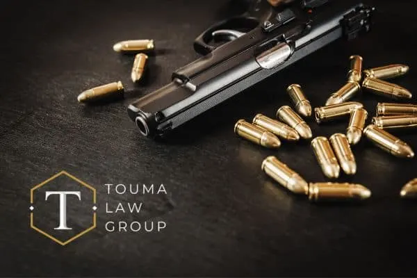 gun on table with gold bullets around