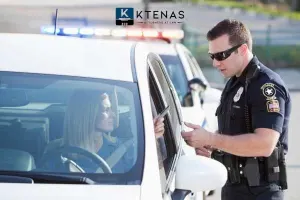 A police officer talking to a woman in a car.