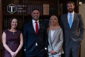 the team at Touma Law Group standing in front of a bookshelf