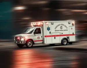 An ambulance speeding down a street with its emergency lights flashing