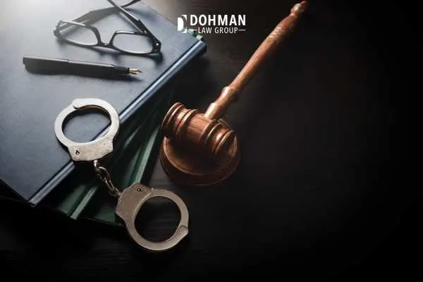 a gavel, law book, and handcuffs on a black table