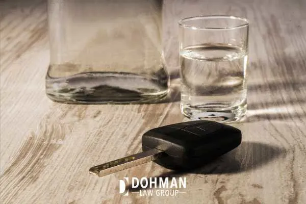 alcohol in a glass and a car key on a table