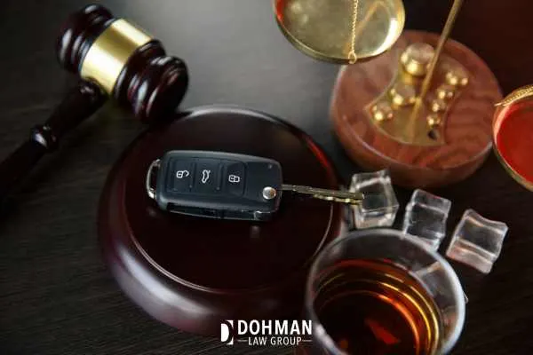 a car key, gavel, and alcohol on a table