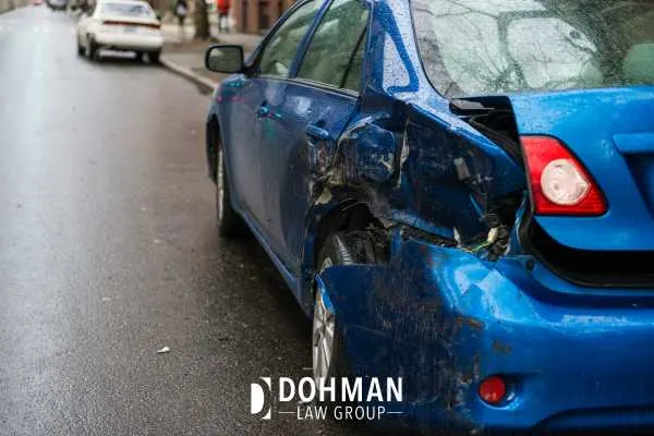 a car with damage to the back side of it parked on a road