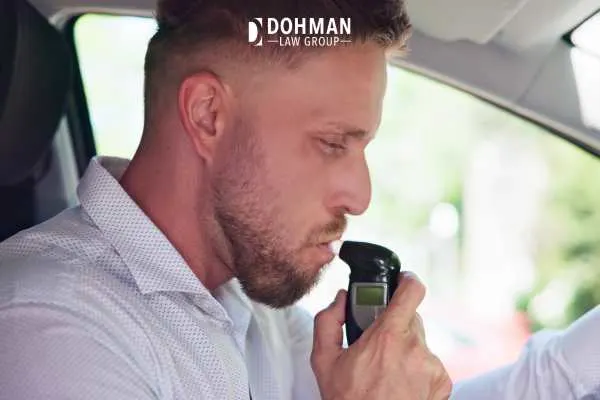 a man blowing into a BAIID to start his vehicle